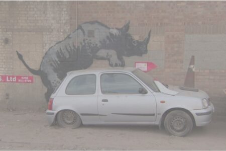 Banksy unveils rhino art that looks as though animal is climbing on a car